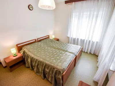 a bedroom with a bed with a blue and white quilt at Apartment La Busa-2 by Interhome in Masarè