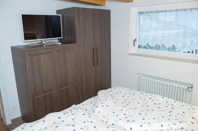 a bedroom with a bed and a tv on a cabinet at Sunshine Apartments in Bolzano