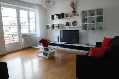 a living room with a flat screen tv and a couch at Sunshine Apartments in Bolzano