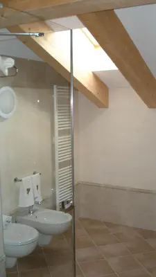 a white tub in a bathroom with a window at Hotel Garni Vittoria in Fiera di Primiero