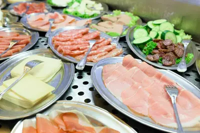 a table topped with plates of food with meats and cheese at La Pergola PanoramaSuites in Tirolo