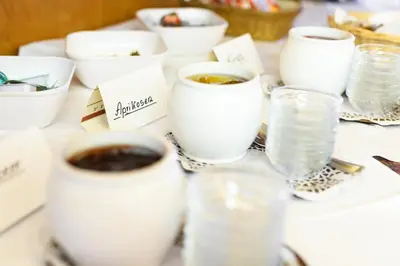 a table with cups of coffee and glasses of water at La Pergola PanoramaSuites in Tirolo