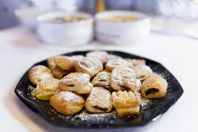 a black plate of doughnuts on a table at La Pergola PanoramaSuites in Tirolo