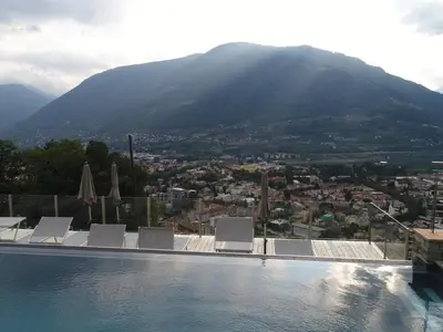a swimming pool with a view of a mountain at La Pergola PanoramaSuites in Tirolo