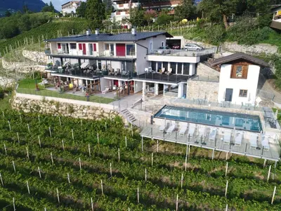 a house on a hill with a swimming pool at La Pergola PanoramaSuites in Tirolo