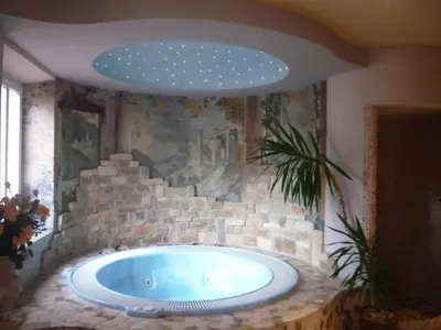 a large bath tub in a room with a stone wall at Hotel Regina in Cortina dʼAmpezzo