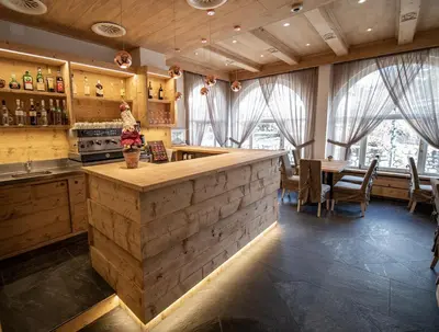 a kitchen with a wooden counter and a dining room at Hotel Regina in Cortina dʼAmpezzo