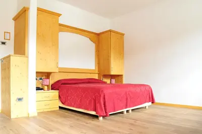 a bedroom with a bed with a red bedspread at Hotel Regina in Cortina dʼAmpezzo