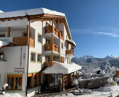 a large building with snow on the ground at Hotel Antermoia in Antermoia