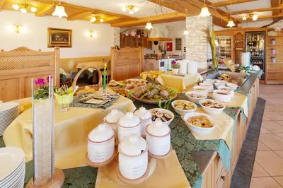 a kitchen with a buffet of food on a table at Hotel Antermoia in Antermoia