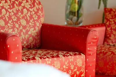 a red chair sitting next to a vase at Hotel Antermoia in Antermoia