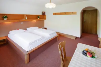 a bedroom with a bed and a table with a bowl of fruit at Hotel Antermoia in Antermoia