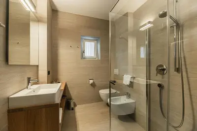 a bathroom with a sink and a toilet and a shower at Aquila Dolomites Residence in Ortisei