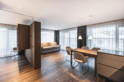 a living room with a table and a couch at Aquila Dolomites Residence in Ortisei
