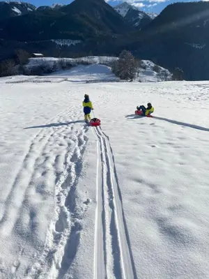 two people in the snow with tracks in the snow at B&B Pichler Casa in Castello di Fiemme