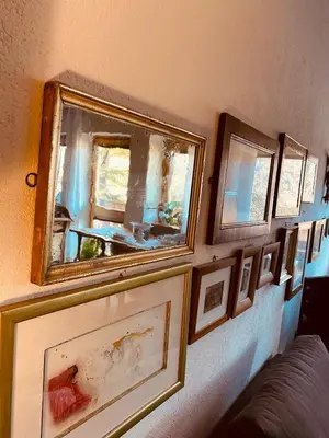 a row of framed pictures on a wall at B&B Pichler Casa in Castello di Fiemme