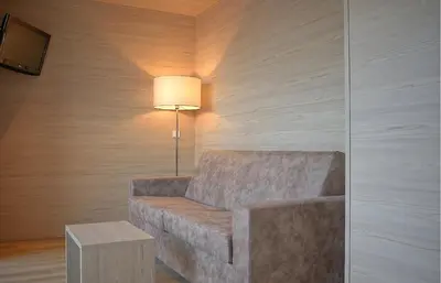 a living room with a couch and a lamp at B&B Boutique Hotel Burgund in Parcines