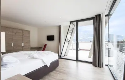 a bedroom with a bed and a large window at B&B Boutique Hotel Burgund in Parcines
