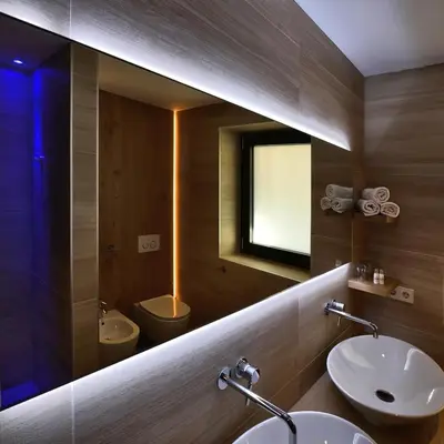 a bathroom with two sinks and a mirror at B&B Boutique Hotel Burgund in Parcines