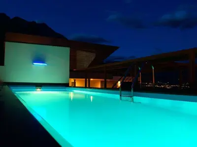 a swimming pool lit up at night at B&B Boutique Hotel Burgund in Parcines