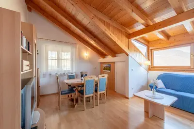 a kitchen with white cabinets and a table in it at Weinberghof in Termeno