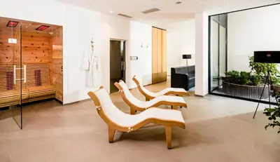 a lobby with four chairs and a dressing room at Hotel Thalhof am See in Caldaro