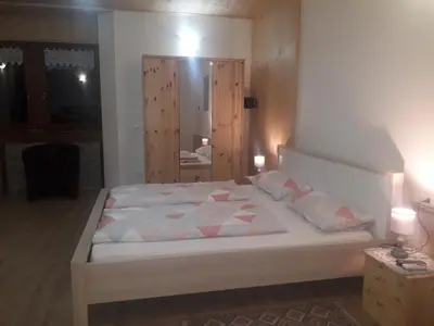 a bedroom with a white bed with a mirror at ATL AGRITURISMO in Salorno sulla Strada del Vino