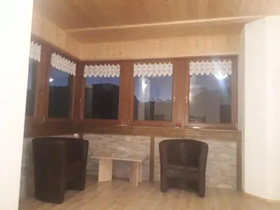 a room with two chairs and a table and windows at ATL AGRITURISMO in Salorno sulla Strada del Vino
