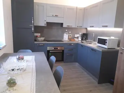 a kitchen with blue cabinets and a table with a microwave at ATL AGRITURISMO in Salorno sulla Strada del Vino