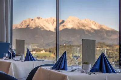 a group of tables with blue napkins and wine glasses at Panoramahotel Obkircher in Nova Ponente