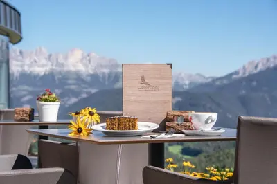a table with a plate of food and a cup of coffee at Panoramahotel Obkircher in Nova Ponente