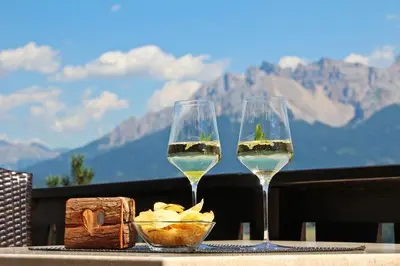 two glasses of white wine sitting on a table at Panoramahotel Obkircher in Nova Ponente