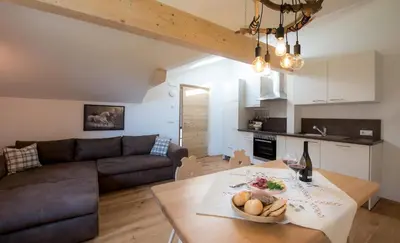 a living room with a table and a couch at Seebacher Apartments in Sarntal
