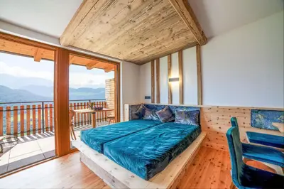 a bedroom with a bed and a balcony at Huberhof in Villandro