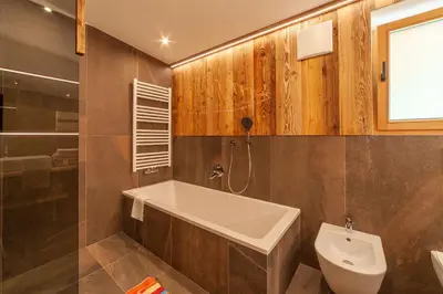 a bathroom with a bath tub and a toilet at Huberhof in Villandro