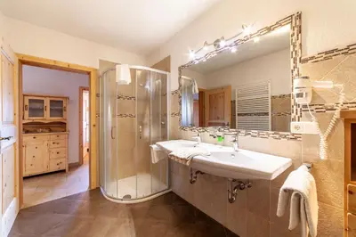 a bathroom with a sink and a shower and a mirror at Huberhof in Villandro