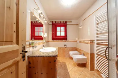 a bathroom with two sinks and a toilet in it at Huberhof in Villandro
