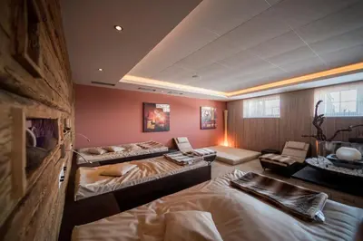a large room with two beds and a couch at Familienhotel Maria in Obereggen