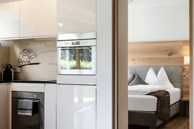 a kitchen with a stove top oven next to a bed at Apartments Chalet Anna in Ortisei