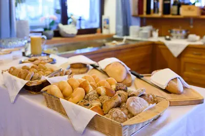 a table topped with trays of different types of bread at Hotel Panorama in Tirolo