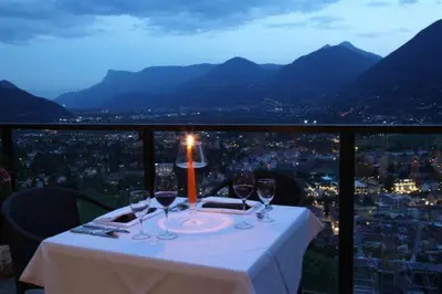 a table with wine glasses and a candle on it at Hotel Panorama in Tirolo