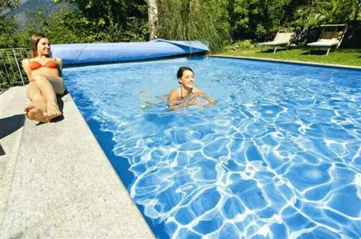 a woman and a man in a swimming pool at Hotel Panorama in Tirolo