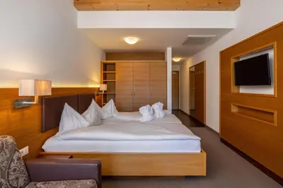 a bedroom with a large bed and a tv at Hotel Panorama in Tirolo
