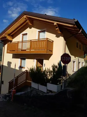 a house with a balcony and a stop sign at Casa Alice 5.3 in Fiera di Primiero