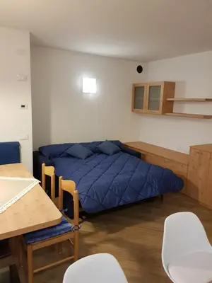 a bedroom with a blue bed in a room at Casa Alice 5.3 in Fiera di Primiero