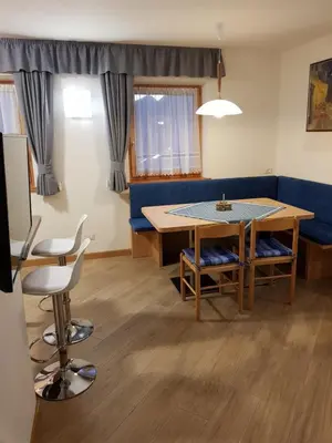 a living room with a table and a blue couch at Casa Alice 5.3 in Fiera di Primiero