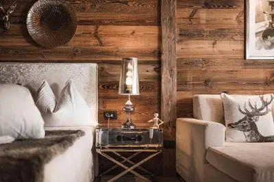 a bedroom with a bed and a side table with a lamp at Alpine Boutique Villa Gabriela - Adults Only in Castelrotto