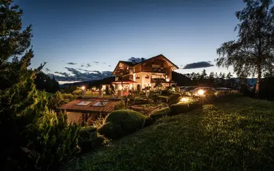 a large house in a field with lights at Alpine Boutique Villa Gabriela - Adults Only in Castelrotto