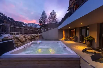 a jacuzzi tub in the middle of a house at Waidacherhof Apartments in Braies