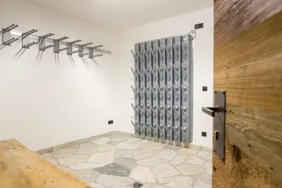 a room with a wall with a bunch of baseball bats at Waidacherhof Apartments in Braies